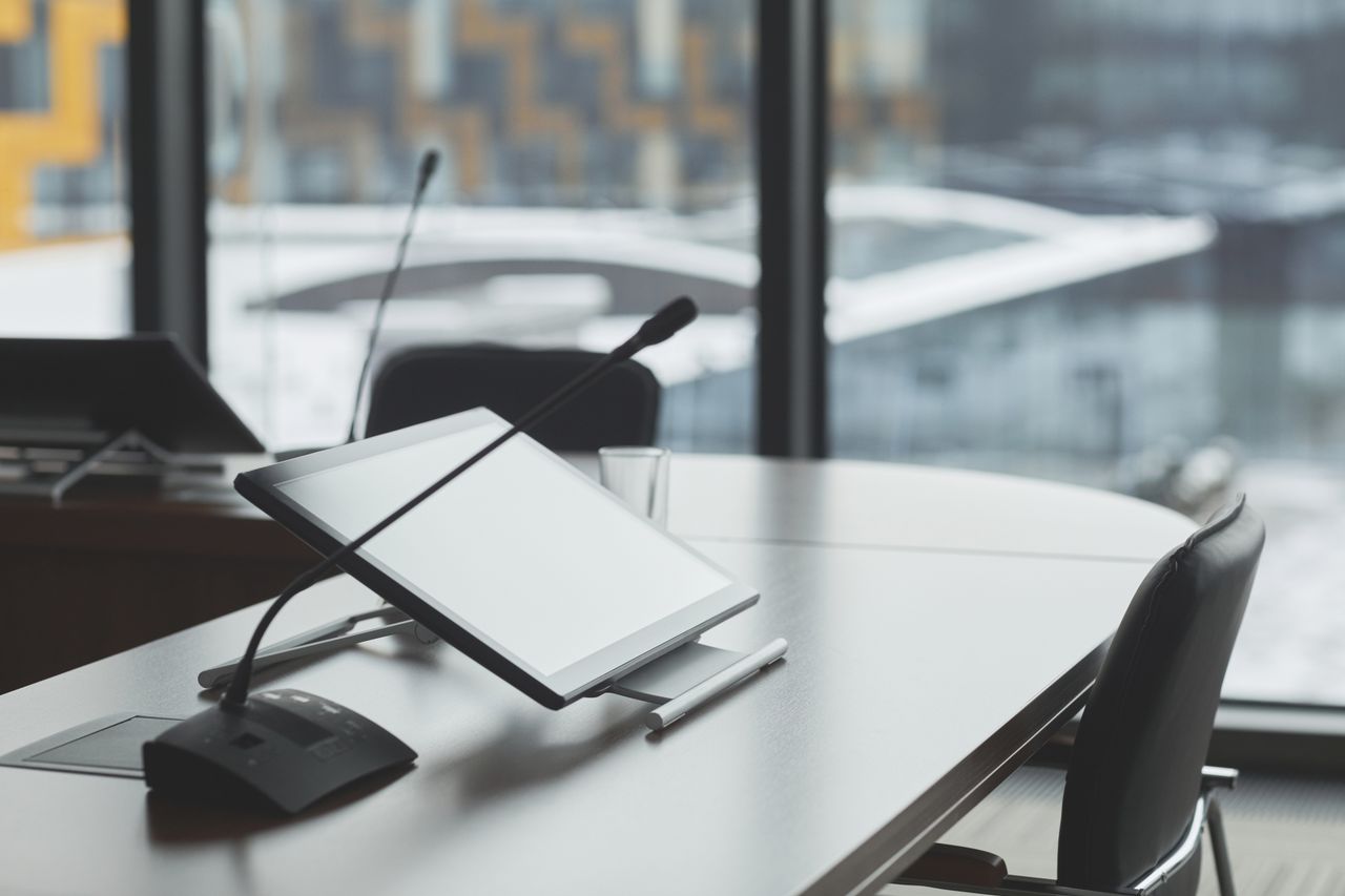 The Art of Drawing Readers In: Your attractive post title goes here High-tech conference room with digital tablets and microphones for effective communication.